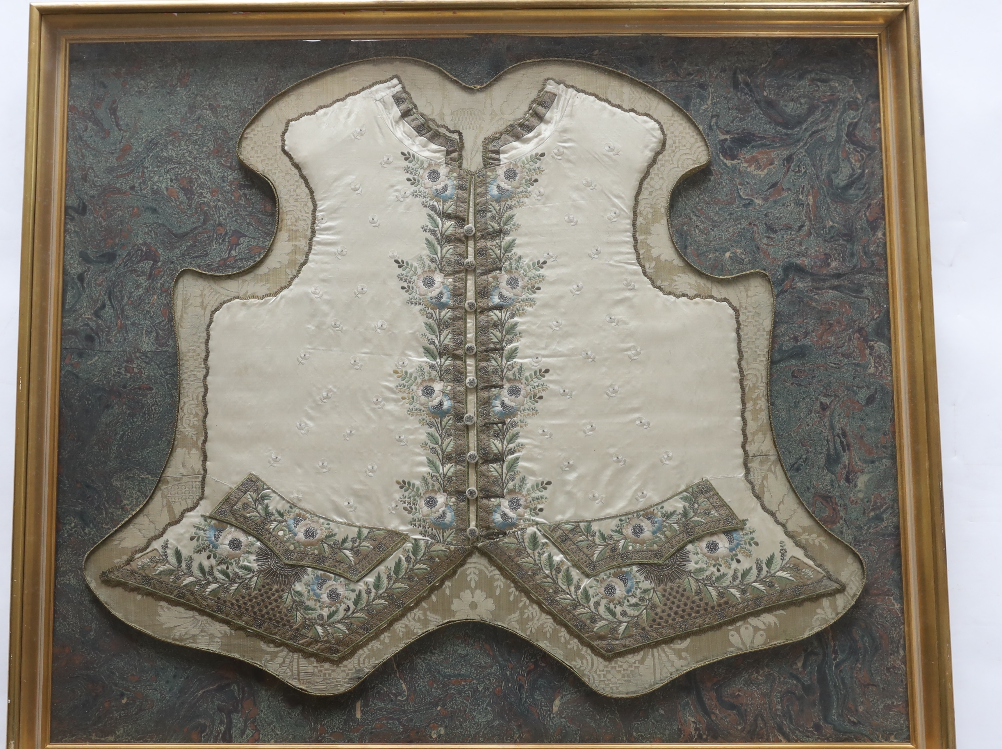 A rare framed George III gentleman’s ivory silk waistcoat front. Embroidered with a fine ivory spot motif and an elaborately embroidered wide floral and leaf designed border, using coloured silks, sequins, fine chenille